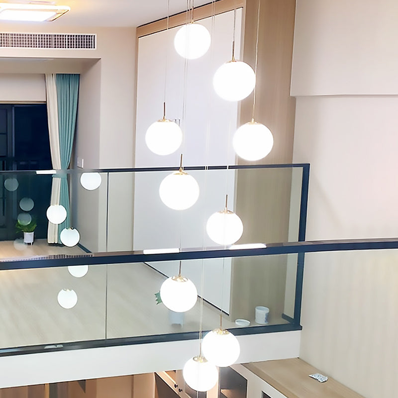 Minimalist Gold Multi-Pendant Ceiling Light with Cream Glass Bubbles and White Glass Staircase Suspension