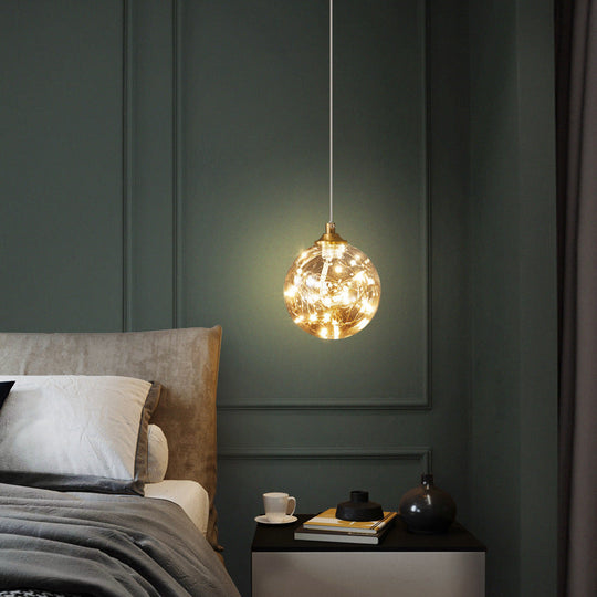 Nordic Amber Glass LED Pendant Lamp with Brass Finish and Starry Design for Bedroom